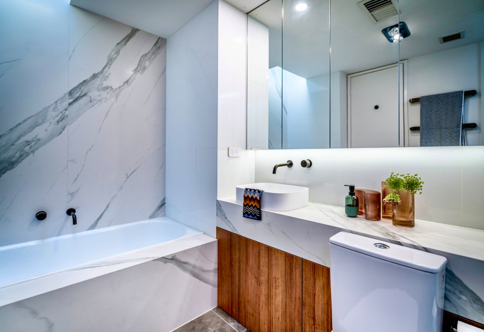 Modern inredning av ett mellanstort vit vitt en-suite badrum, med möbel-liknande, skåp i mörkt trä, ett platsbyggt badkar, en öppen dusch, vit kakel, cementkakel, vita väggar, klinkergolv i keramik, ett fristående handfat, bänkskiva i kvarts och grått golv