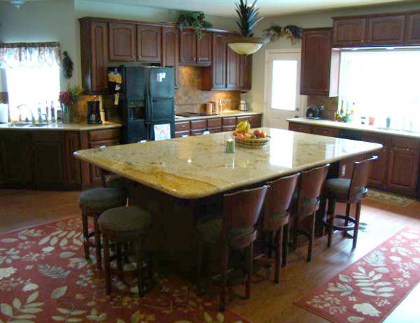 Example of a large transitional u-shaped medium tone wood floor and brown floor eat-in kitchen design in Houston with raised-panel cabinets, medium tone wood cabinets, granite countertops, beige backsplash, travertine backsplash, black appliances and an island