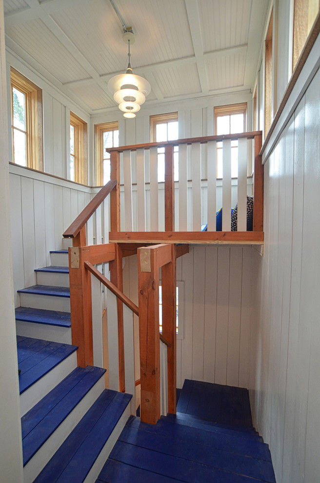 Beach style painted wood l-shaped staircase in Portland Maine with painted wood risers.