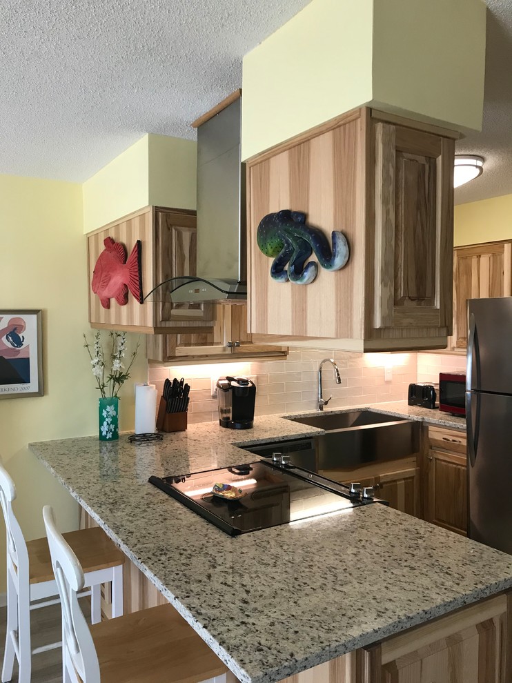 Enclosed kitchen - small rustic u-shaped porcelain tile and beige floor enclosed kitchen idea with a farmhouse sink, raised-panel cabinets, medium tone wood cabinets, granite countertops, white backsplash, glass tile backsplash, stainless steel appliances, a peninsula and beige countertops
