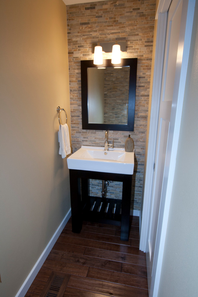 This is an example of a small transitional powder room in Portland with open cabinets, dark wood cabinets, stone tile, beige walls and an integrated sink.