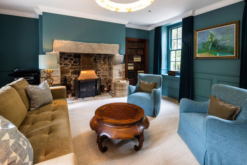 Diseño de salón para visitas cerrado campestre sin televisor con paredes azules, estufa de leña, marco de chimenea de piedra, suelo beige y panelado