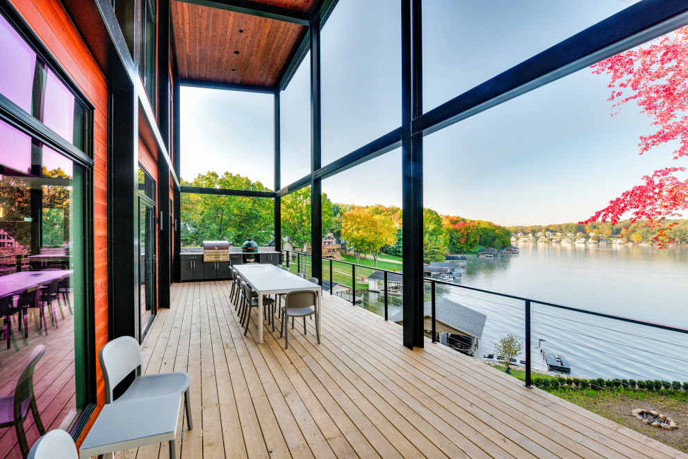 Design ideas for a contemporary first floor deck in Cleveland with a roof extension and cable railing.