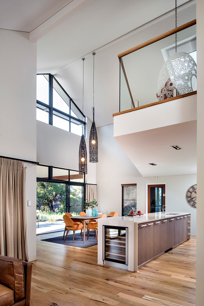 Inspiration for an expansive contemporary galley open plan kitchen in Perth with an undermount sink, flat-panel cabinets, medium wood cabinets, light hardwood floors and with island.