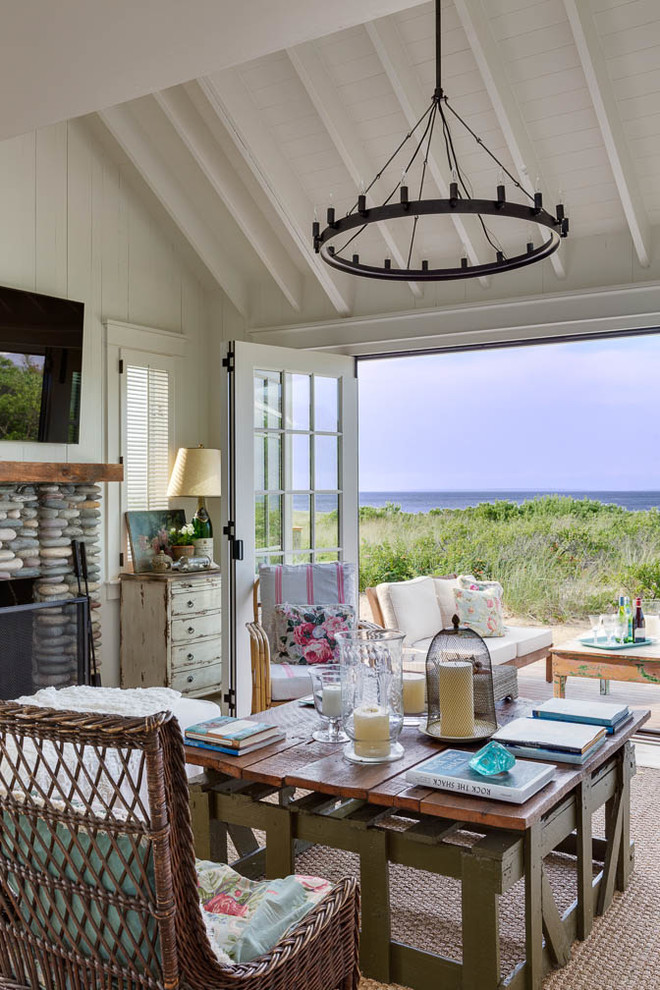Small beach style open concept light wood floor living room photo with white walls, a standard fireplace, a stone fireplace and a wall-mounted tv
