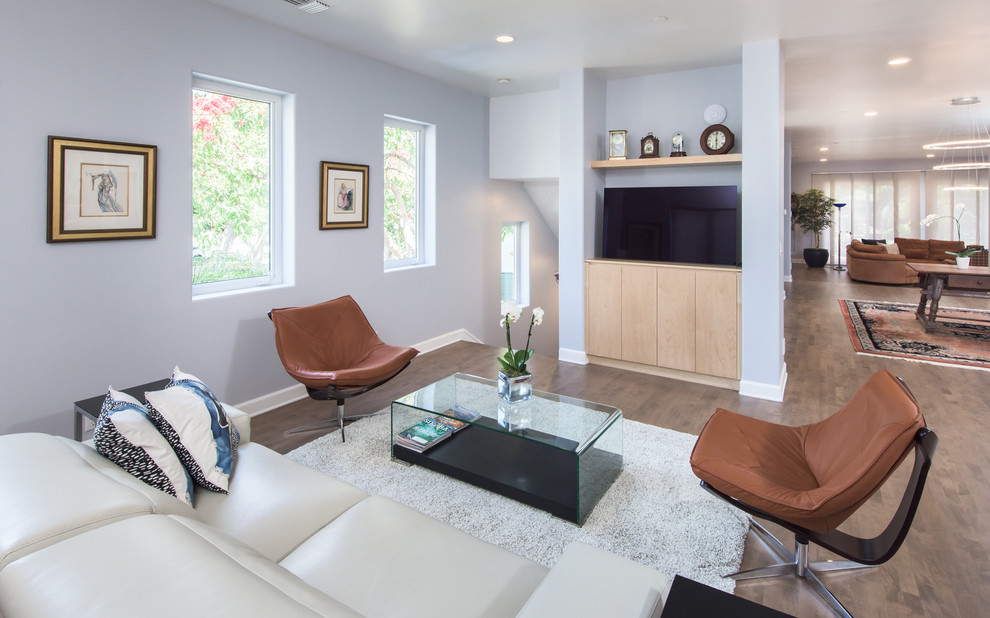 Photo of a mid-sized contemporary open concept family room in Los Angeles with grey walls, medium hardwood floors, a standard fireplace, a stone fireplace surround, a built-in media wall and brown floor.