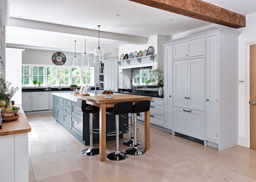 Photo of a large modern l-shaped kitchen/diner in Berkshire with a built-in sink, recessed-panel cabinets, blue cabinets, quartz worktops, blue splashback, engineered quartz splashback, black appliances, limestone flooring, an island, brown floors, blue worktops and a drop ceiling.