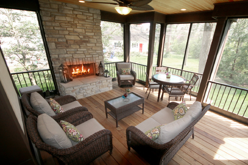 This is an example of a mid-sized contemporary sunroom in St Louis with light hardwood floors, a standard fireplace, a brick fireplace surround, a standard ceiling and brown floor.