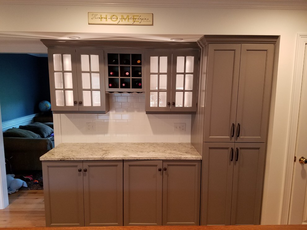 Example of a mid-sized transitional galley light wood floor and brown floor eat-in kitchen design with a farmhouse sink, recessed-panel cabinets, gray cabinets, wood countertops, white backsplash, subway tile backsplash, stainless steel appliances and an island