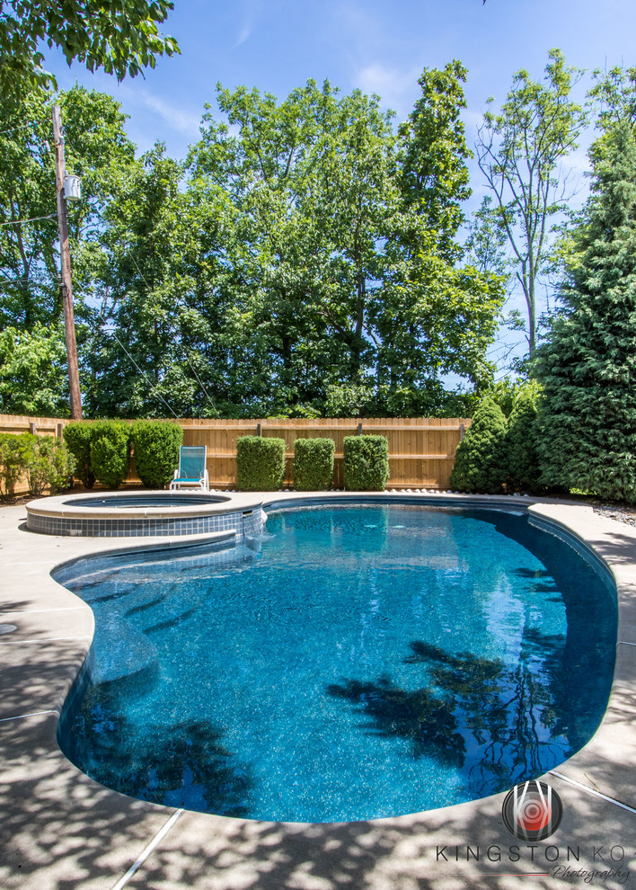 Example of a mid-sized transitional backyard kidney-shaped hot tub design in Philadelphia