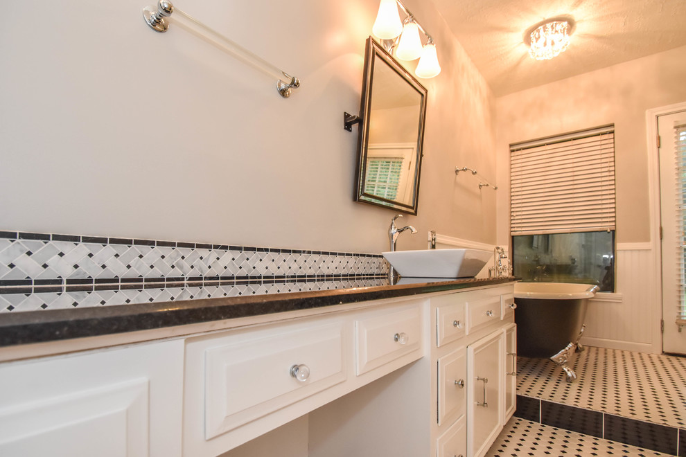 Photo of a transitional bathroom in Houston with raised-panel cabinets, white cabinets, a claw-foot tub, an open shower, a one-piece toilet, black and white tile, mosaic tile, grey walls, mosaic tile floors, a vessel sink and granite benchtops.