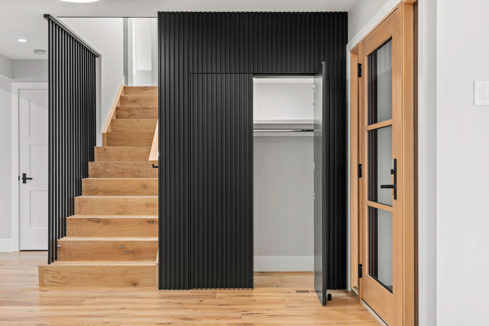 Cette image montre un escalier droit minimaliste avec des contremarches en bois, un garde-corps en métal et du lambris.