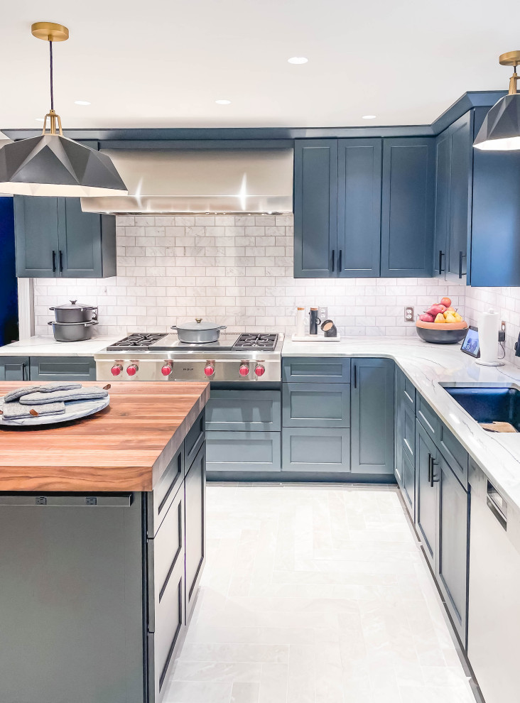 Large country l-shaped eat-in kitchen in Baltimore with an undermount sink, shaker cabinets, blue cabinets, quartzite benchtops, white splashback, subway tile splashback, stainless steel appliances, porcelain floors, with island, grey floor and white benchtop.