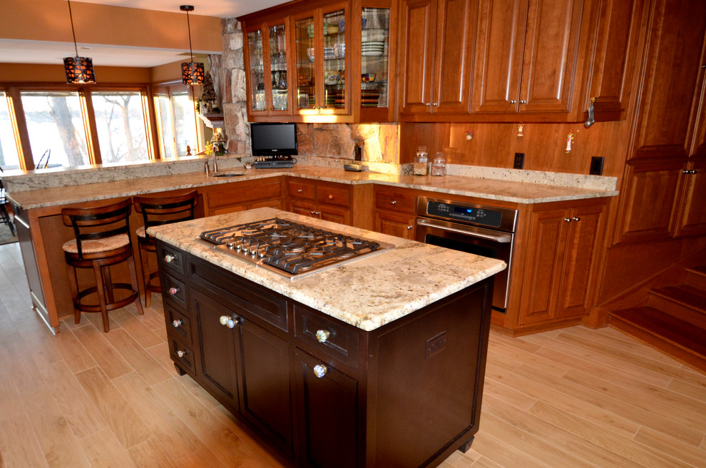 Eat-in kitchen - transitional l-shaped medium tone wood floor eat-in kitchen idea in Milwaukee with a single-bowl sink, beaded inset cabinets, medium tone wood cabinets, granite countertops, stone slab backsplash, stainless steel appliances and an island