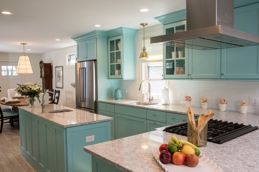 Photo of a small beach style l-shaped eat-in kitchen in Other with with island, an undermount sink, flat-panel cabinets, turquoise cabinets, quartz benchtops, white splashback, ceramic splashback, stainless steel appliances, vinyl floors and grey floor.
