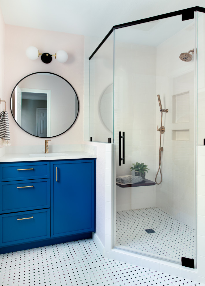 Пример оригинального дизайна: ванная комната в стиле неоклассика (современная классика) с фасадами в стиле шейкер, синими фасадами, душем в нише, розовыми стенами, душевой кабиной, врезной раковиной, столешницей из искусственного кварца, разноцветным полом, душем с распашными дверями, белой столешницей, тумбой под одну раковину и встроенной тумбой