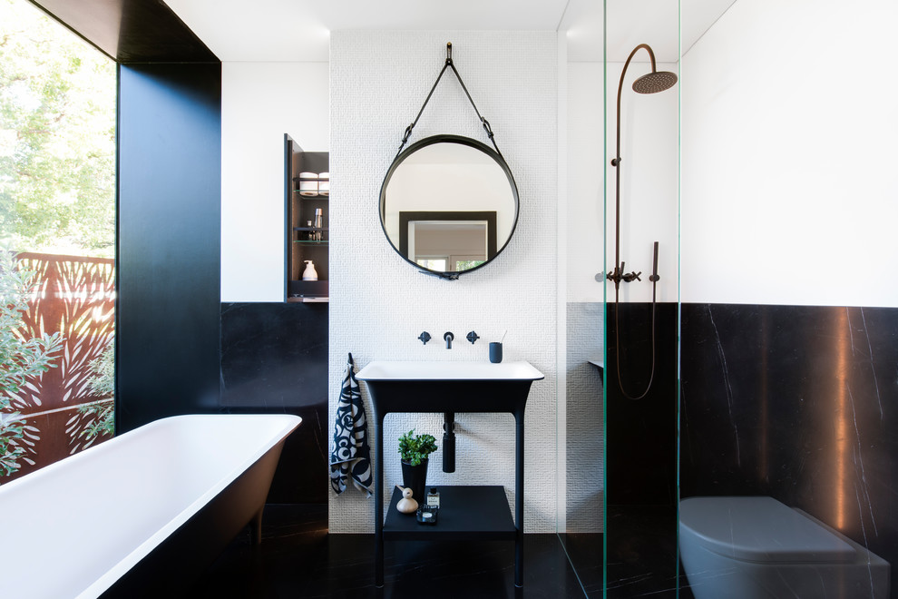 Photo of a small modern master bathroom in Sydney with flat-panel cabinets, black cabinets, a freestanding tub, an open shower, a wall-mount toilet, white tile, marble, white walls, marble floors, a pedestal sink, black floor and an open shower.
