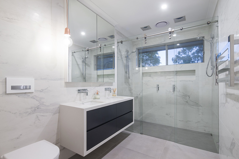 Design ideas for a mid-sized modern master bathroom in Sydney with flat-panel cabinets, black cabinets, a double shower, a wall-mount toilet, gray tile, ceramic tile, multi-coloured walls, ceramic floors, an undermount sink and granite benchtops.