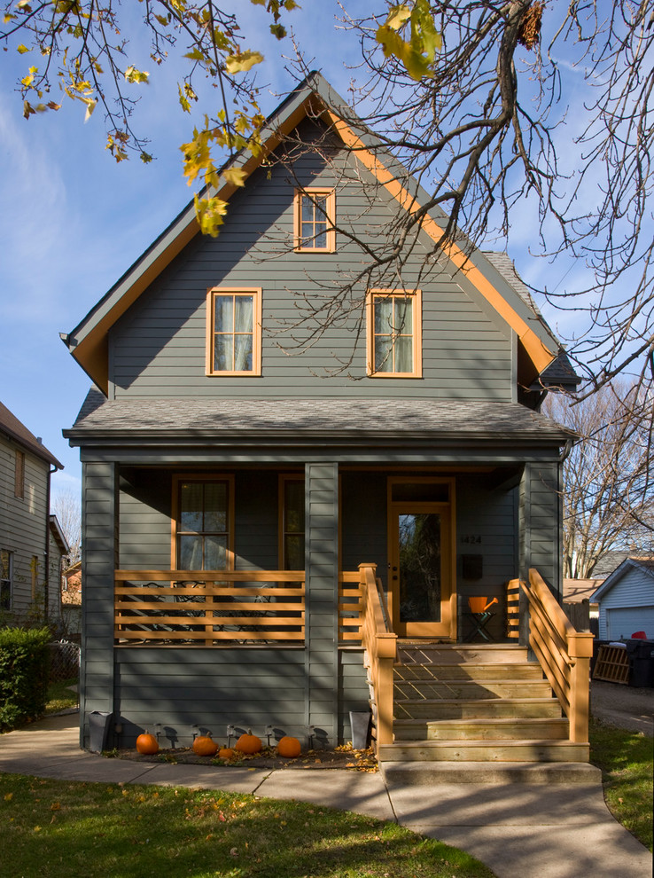 Traditional two-storey grey house exterior in Chicago with a gable roof and a shingle roof.