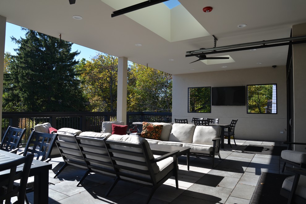 Large transitional stone outdoor kitchen porch idea in Chicago with a roof extension