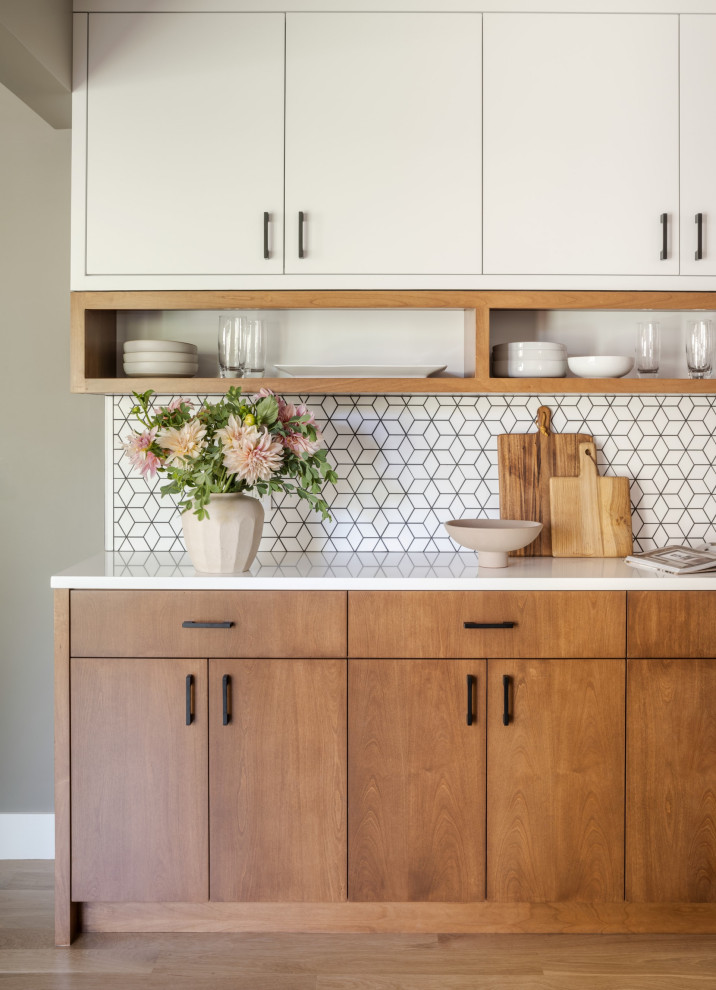 Inspiration for a mid-sized scandinavian home bar in Portland with an undermount sink, flat-panel cabinets, light wood cabinets, white splashback, mosaic tile splashback, light hardwood floors and white benchtop.