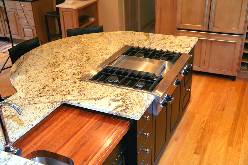 Example of a mid-sized transitional l-shaped light wood floor and beige floor enclosed kitchen design in Milwaukee with recessed-panel cabinets, light wood cabinets, granite countertops, stainless steel appliances, an island and an undermount sink