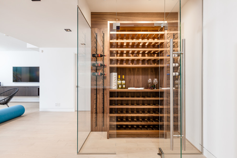 Inspiration for a mid-sized contemporary wine cellar in Toronto with light hardwood floors, storage racks and brown floor.