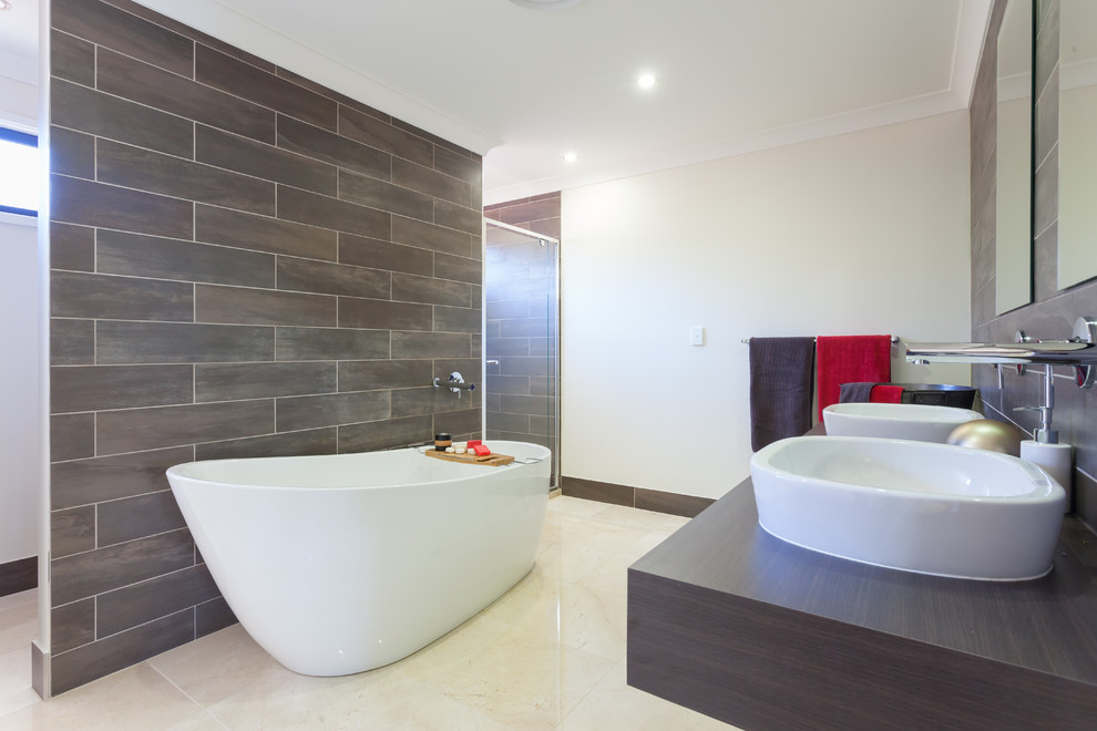 Photo of a large contemporary bathroom in Brisbane with a vessel sink, dark wood cabinets and marble floors.