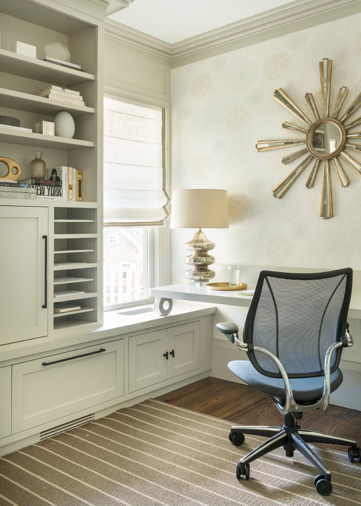 Transitional study room in New York with beige walls, dark hardwood floors and a built-in desk.