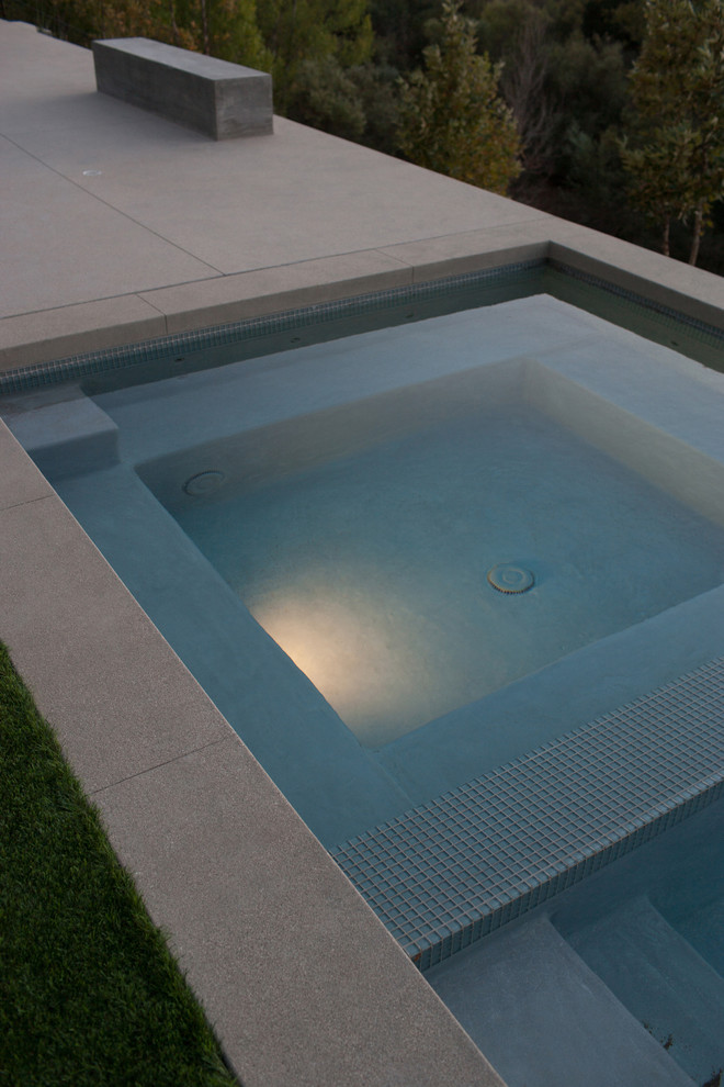 Inspiration for an expansive contemporary front yard rectangular lap pool in Other with a hot tub and tile.