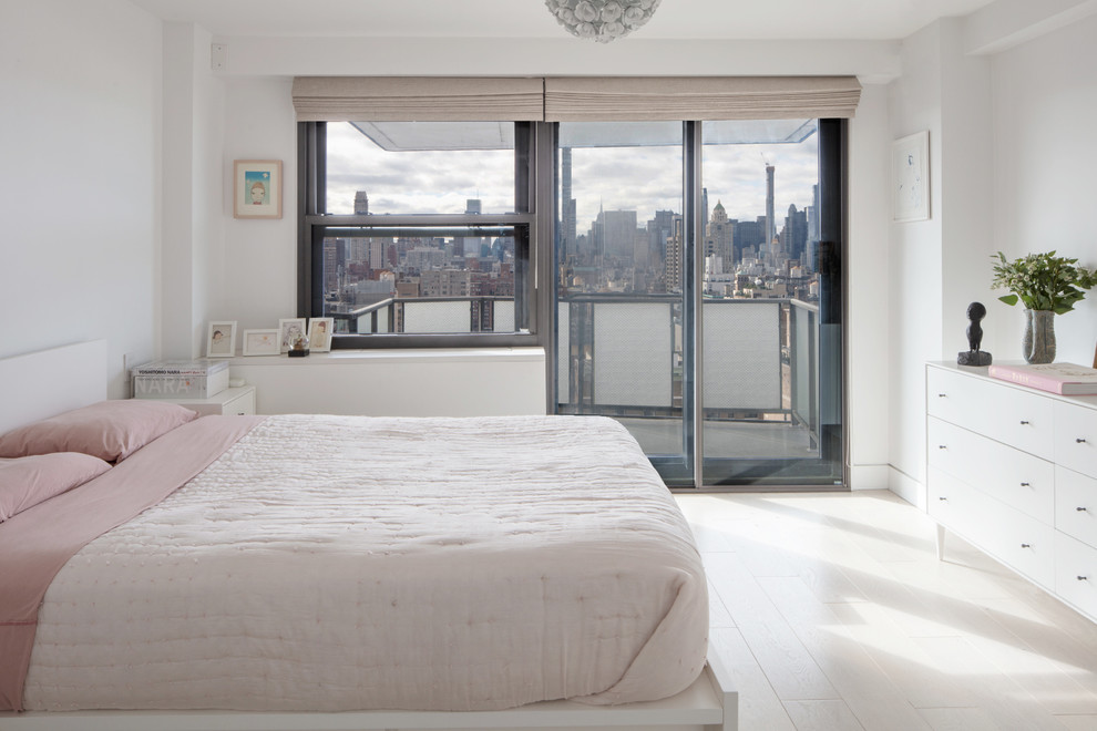 Design ideas for a scandinavian master bedroom in New York with white walls and light hardwood floors.