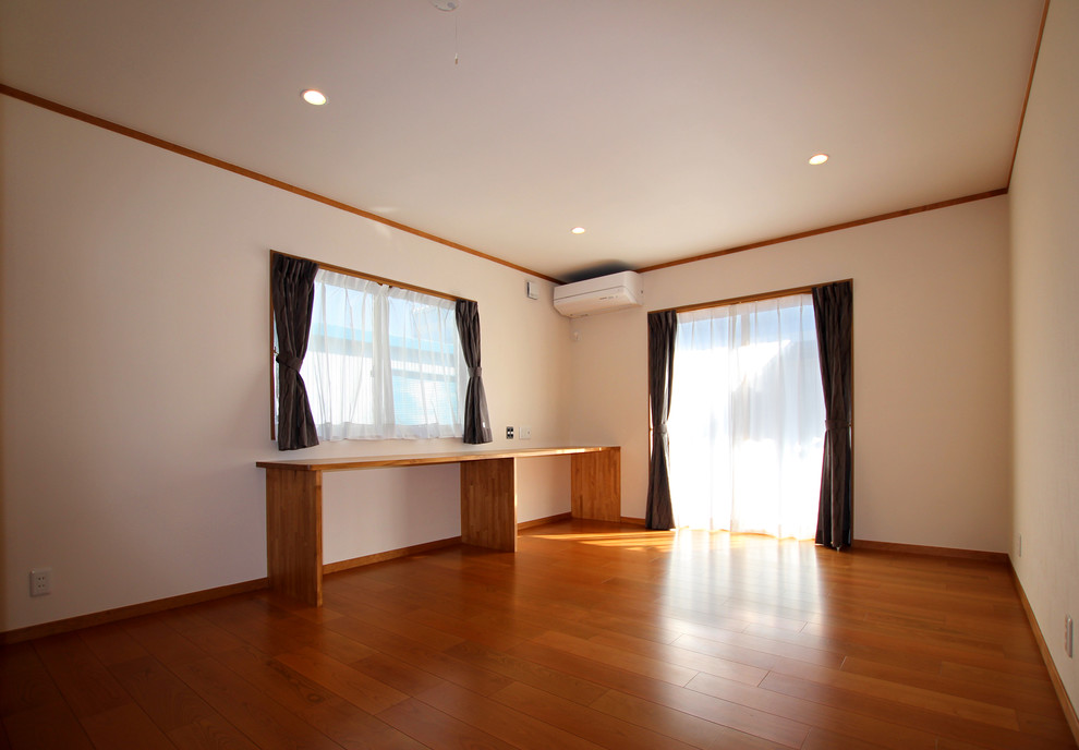 Esempio di una piccola camera matrimoniale moderna con pareti bianche, pavimento in compensato e pavimento marrone