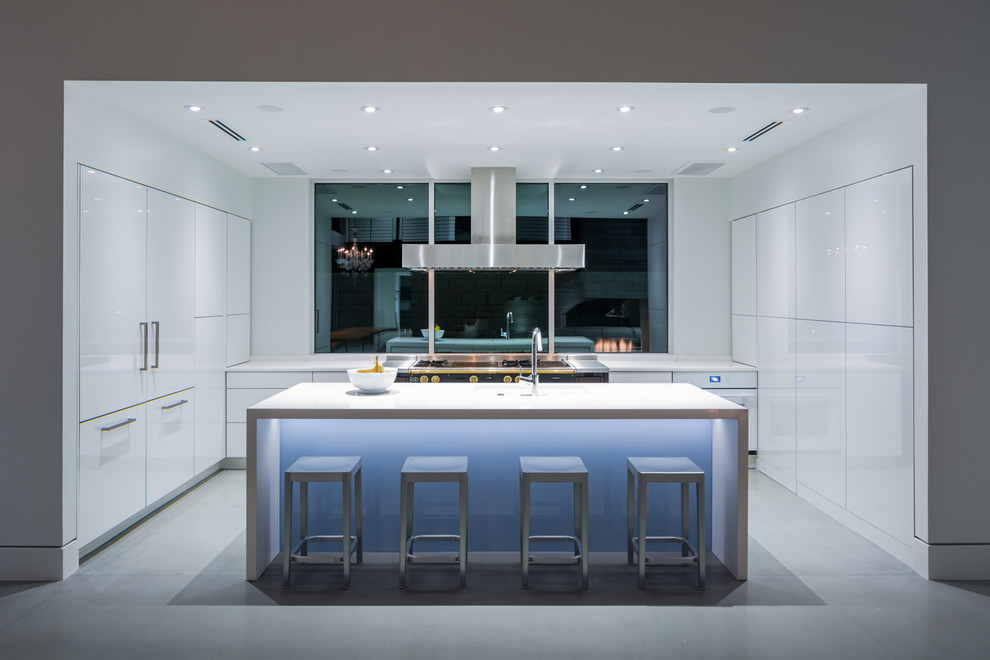Design ideas for a mid-sized contemporary kitchen in Orlando with flat-panel cabinets, white cabinets, quartz benchtops, glass sheet splashback, concrete floors and with island.