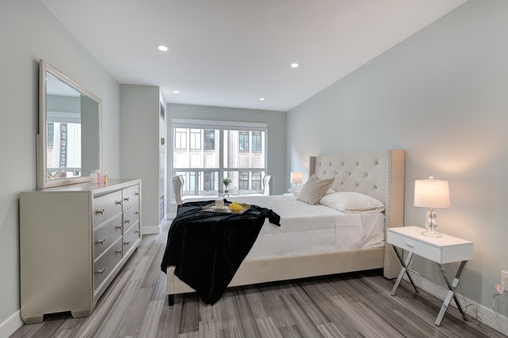 This is an example of a large modern master bedroom in Toronto with grey floor, grey walls and light hardwood floors.