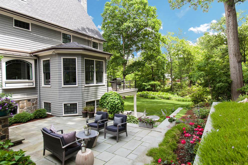 This is an example of a large traditional backyard patio in Boston.