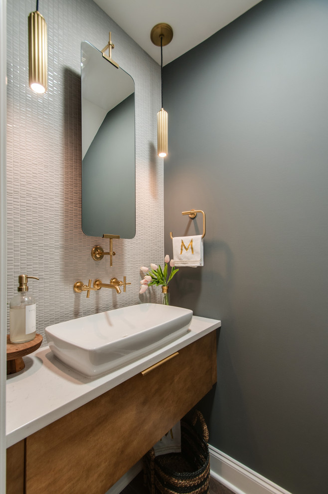 Small retro cloakroom in Nashville with freestanding cabinets, brown cabinets, a one-piece toilet, grey tiles, porcelain tiles, grey walls, medium hardwood flooring, a vessel sink, engineered stone worktops, white worktops and a floating vanity unit.