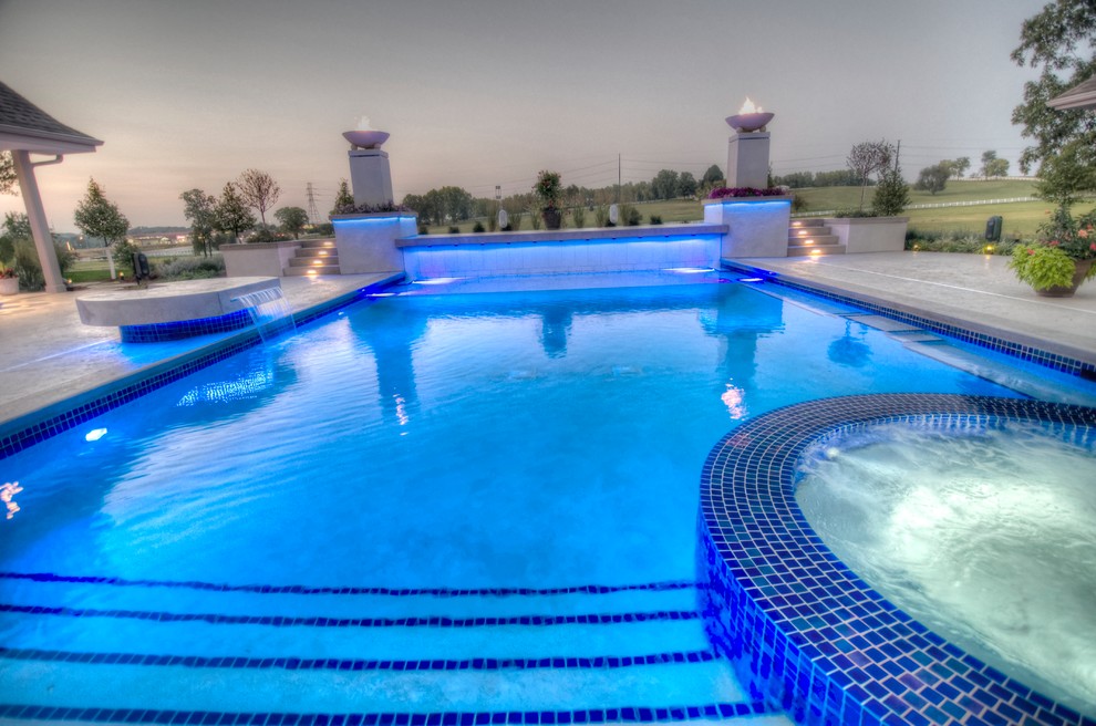 Example of a large transitional backyard concrete paver and rectangular natural hot tub design in Cedar Rapids