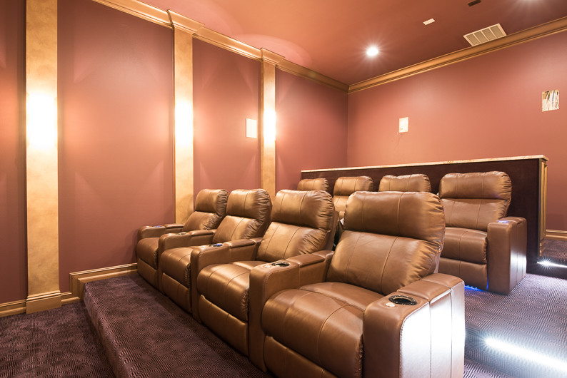 Photo of a transitional enclosed home theatre in Orlando with carpet and a projector screen.