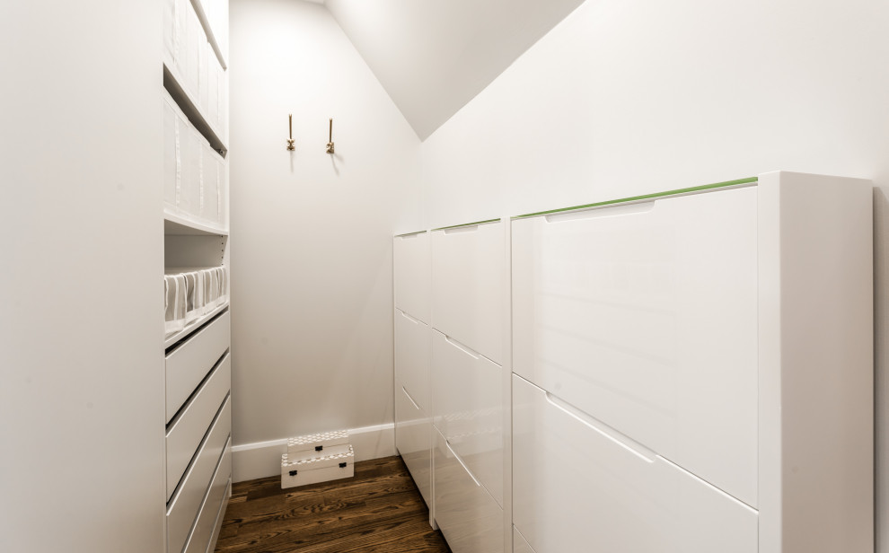 Large contemporary gender neutral built-in wardrobe in Montreal with flat-panel cabinets, white cabinets, medium hardwood flooring and brown floors.