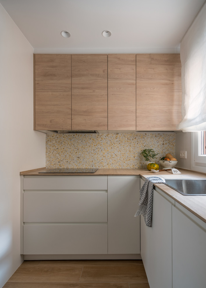 Design ideas for a small mediterranean u-shaped separate kitchen in Bilbao with a farmhouse sink, flat-panel cabinets, white cabinets, wood benchtops, multi-coloured splashback, terra-cotta splashback, panelled appliances, ceramic floors, no island, brown floor and brown benchtop.
