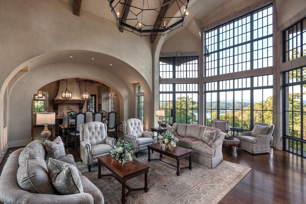Large mediterranean formal open concept living room in Other with beige walls, medium hardwood floors, brown floor, a standard fireplace and a stone fireplace surround.