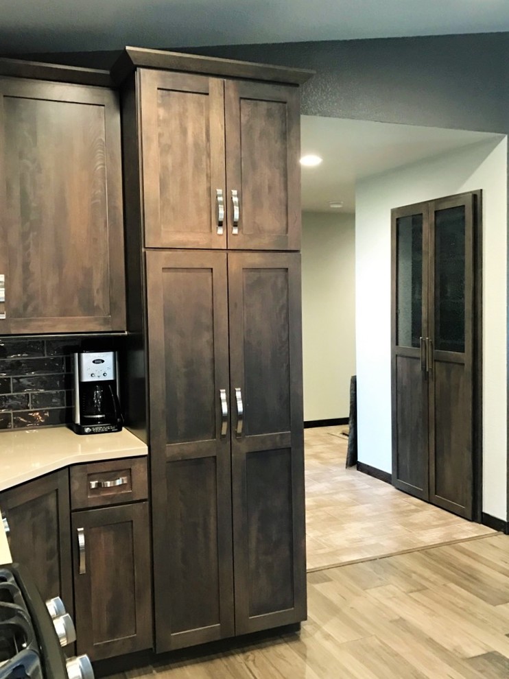 Mid-sized transitional single-wall light wood floor open concept kitchen photo with shaker cabinets, dark wood cabinets, multicolored backsplash, glass tile backsplash, stainless steel appliances, an island, a farmhouse sink and granite countertops