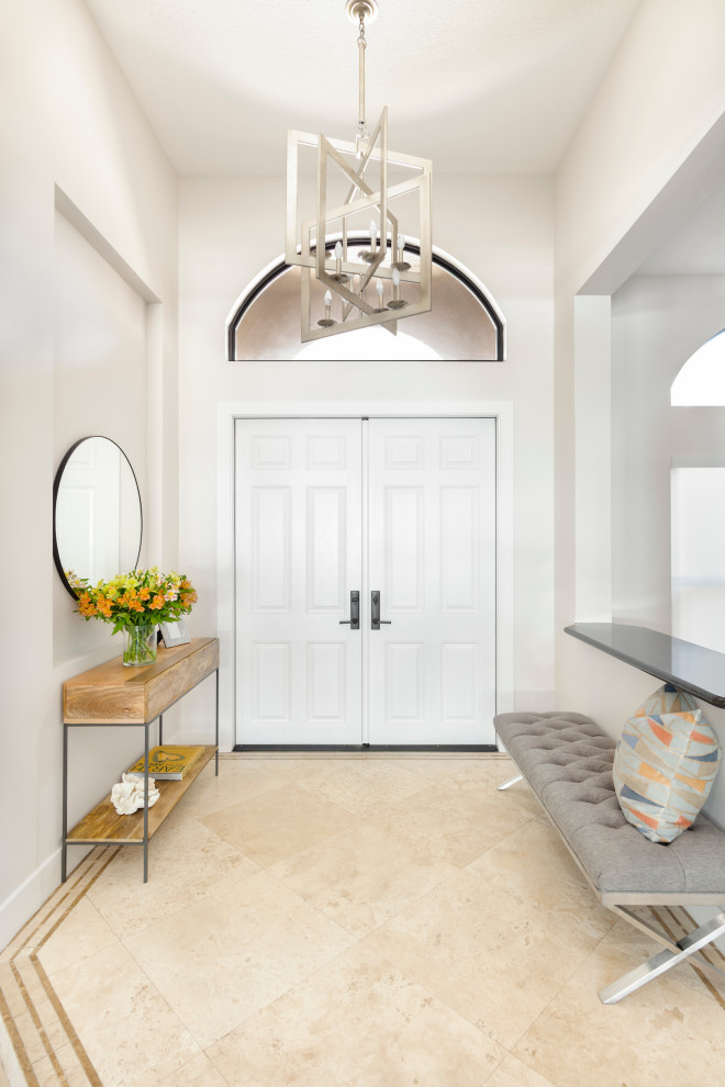 Cette image montre un hall d'entrée design de taille moyenne avec un mur gris, une porte double, une porte blanche et un sol beige.