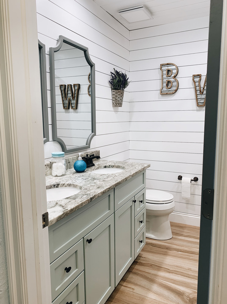 This is an example of a mid-sized country kids bathroom in Other with shaker cabinets, green cabinets, a hot tub, a shower/bathtub combo, a one-piece toilet, white tile, subway tile, white walls, ceramic floors, an undermount sink, granite benchtops, beige floor, a shower curtain and grey benchtops.