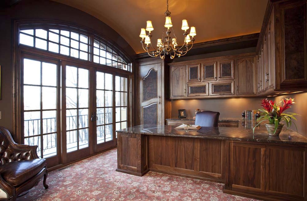 This is an example of a traditional home office in Minneapolis with brown walls, carpet and a built-in desk.