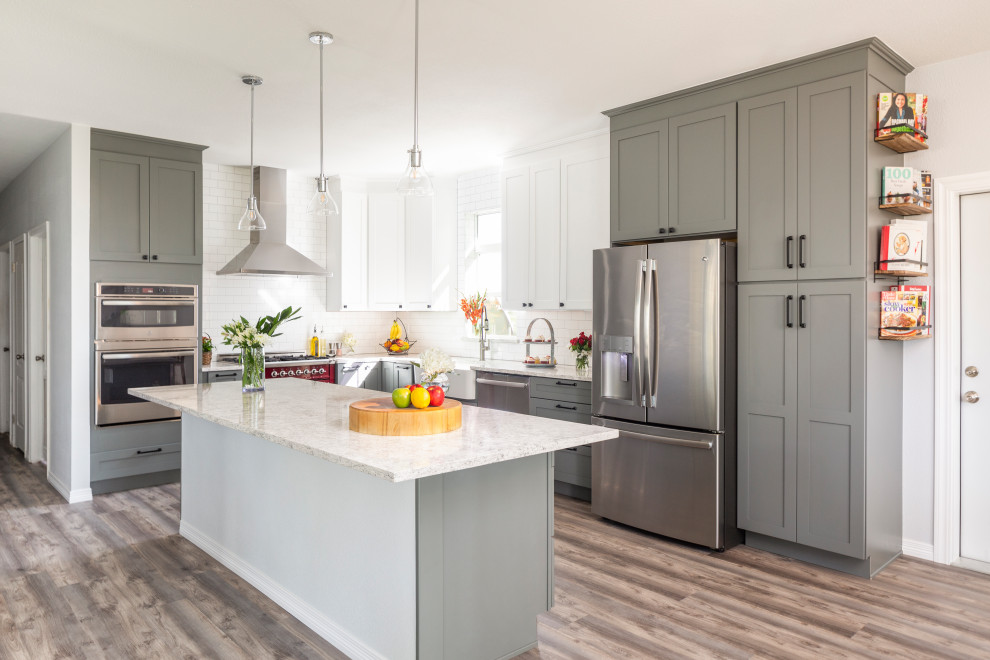 Design ideas for a large modern l-shaped eat-in kitchen in Denver with a farmhouse sink, shaker cabinets, white splashback, with island, grey floor, grey cabinets, quartz benchtops, ceramic splashback, stainless steel appliances, light hardwood floors and white benchtop.