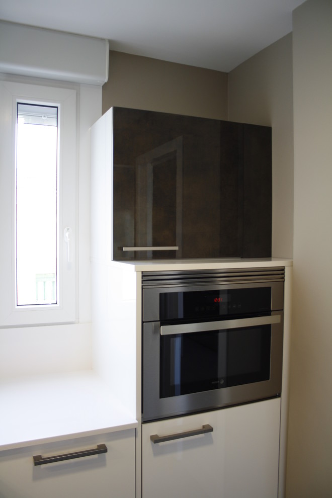 Foto de cocina tradicional renovada pequeña sin isla con fregadero bajoencimera, armarios con paneles lisos, puertas de armario blancas y electrodomésticos de acero inoxidable