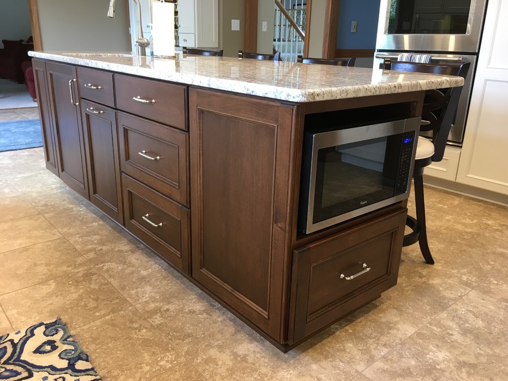 Large transitional l-shaped vinyl floor and beige floor eat-in kitchen photo with a double-bowl sink, recessed-panel cabinets, white cabinets, granite countertops, brown backsplash, ceramic backsplash, stainless steel appliances and an island