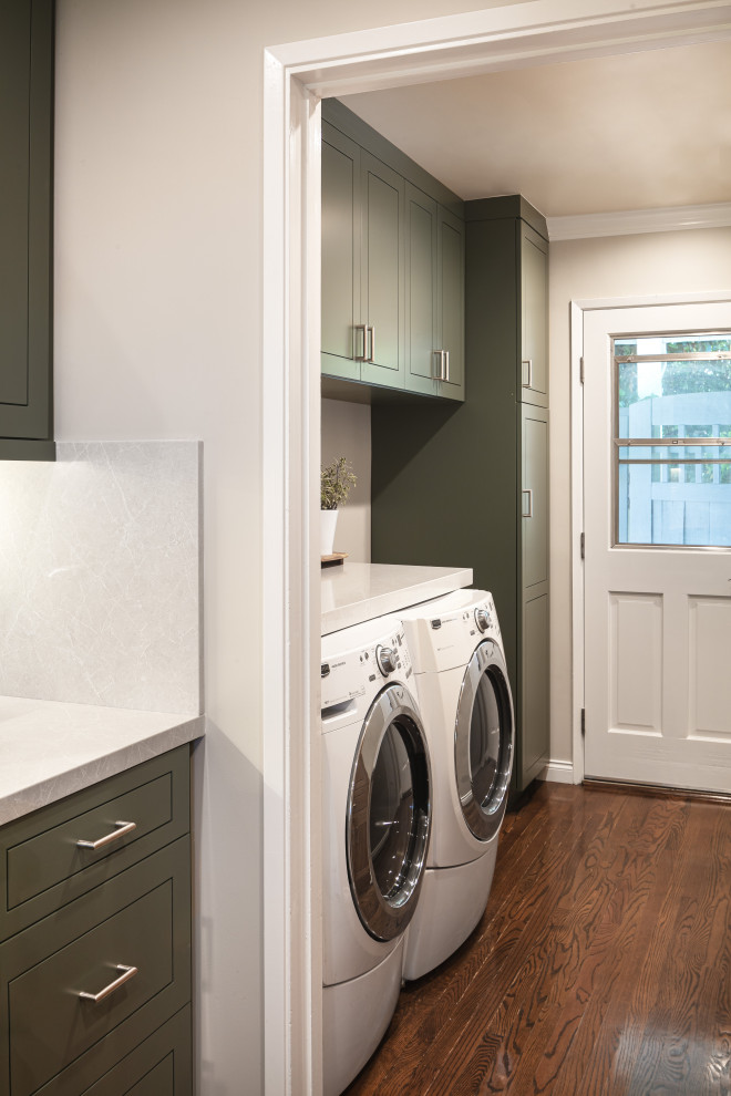 Photo of a small eclectic galley dedicated laundry room in Los Angeles with raised-panel cabinets, green cabinets, quartz benchtops, beige walls, dark hardwood floors, a side-by-side washer and dryer and white benchtop.