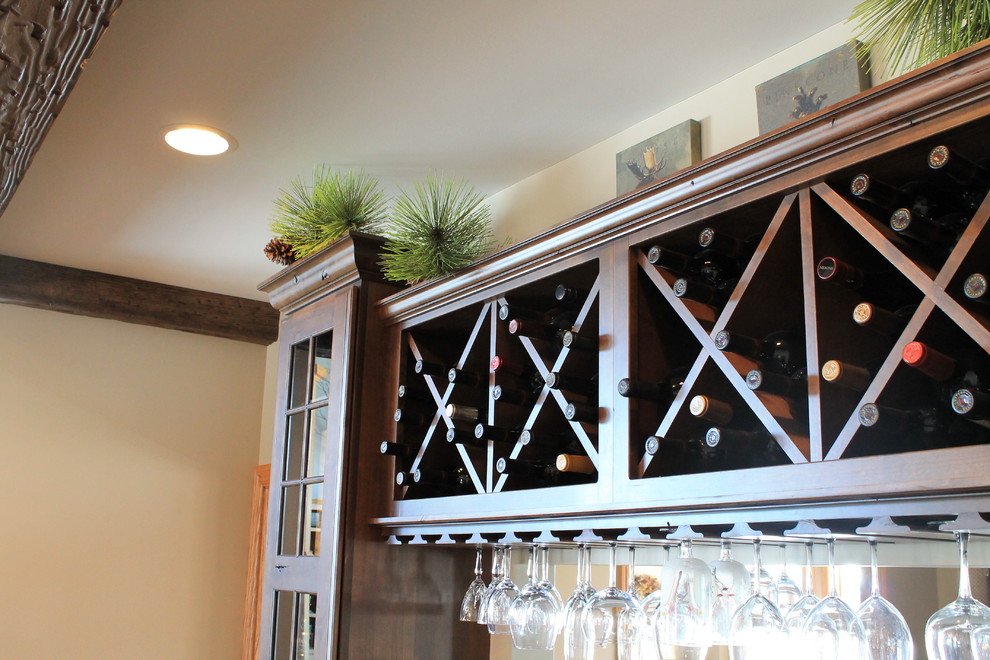 Inspiration for a mid-sized rustic u-shaped medium tone wood floor kitchen remodel with raised-panel cabinets, dark wood cabinets, granite countertops, beige backsplash, ceramic backsplash, black appliances and an island